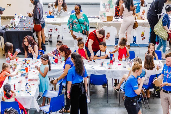Groups of young people and adult at tables, participating in arts activities at artsdepot.