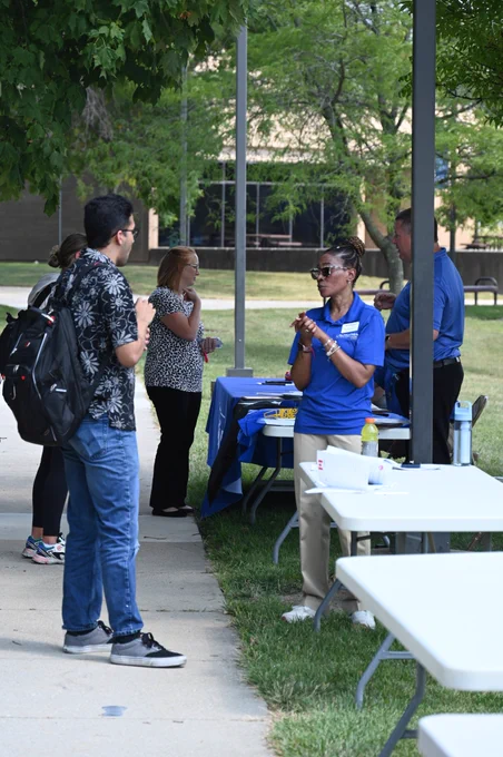 Faculty and staff talk to students on the first day of Fall Semester at a community involvement fair. 