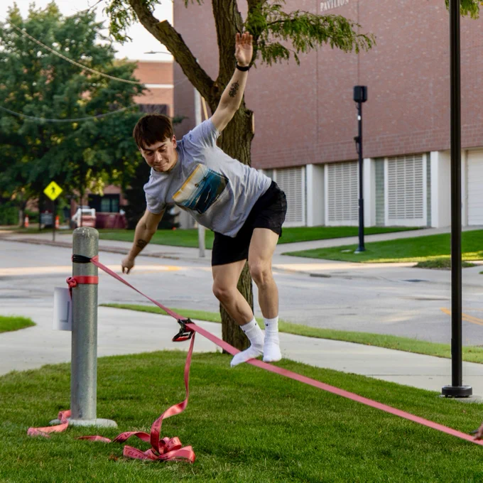 A student balancing on a slackline. 