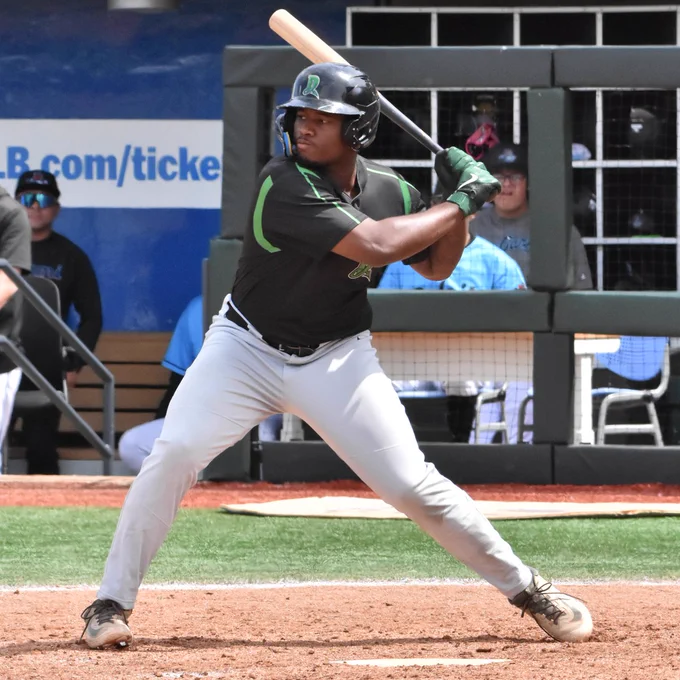 Cam Collier bats in a black Dayton Dragons jersey and grey pants