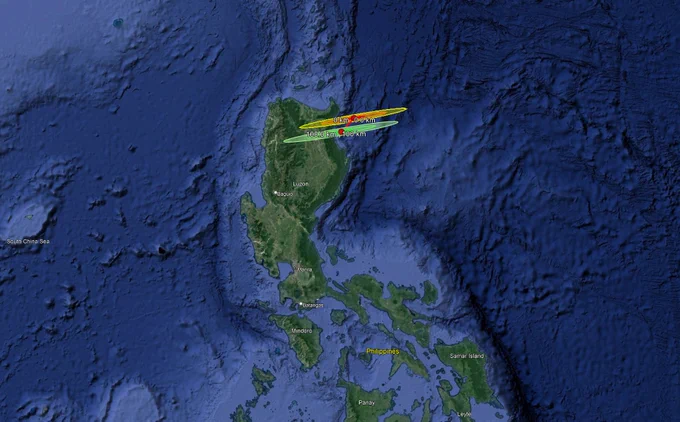 Image of the path of a meteor shown in green and yellow on top of a Google Map image of the the Philippines near Luzon Island shown in dark green contrasting with the deep blue of the ocean.