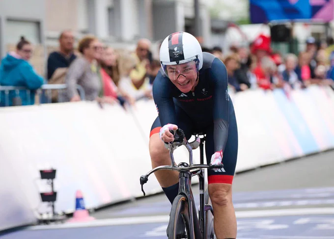 Sarah crossing the line in the road cycling in Paris smiling