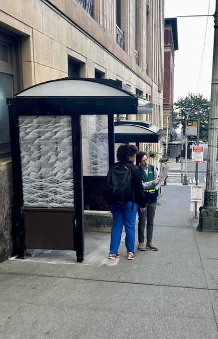 A King County Metro employee showing a rider a route change diagram.