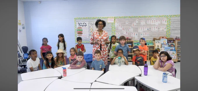 Director of Education Camille Williams-Taylor surrounded by elementary students.