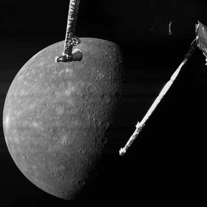 Grey cratered and pock-marked planet, with spacecraft parts visible in the foreground.