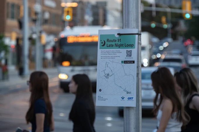 Notice for the Route 91 Late Night Loop, with students walking and a bus in the background.