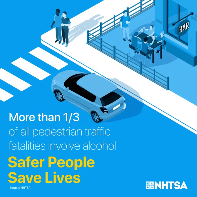A car stopped at a crosswalk with people standing on the sidewalk waiting to walk.