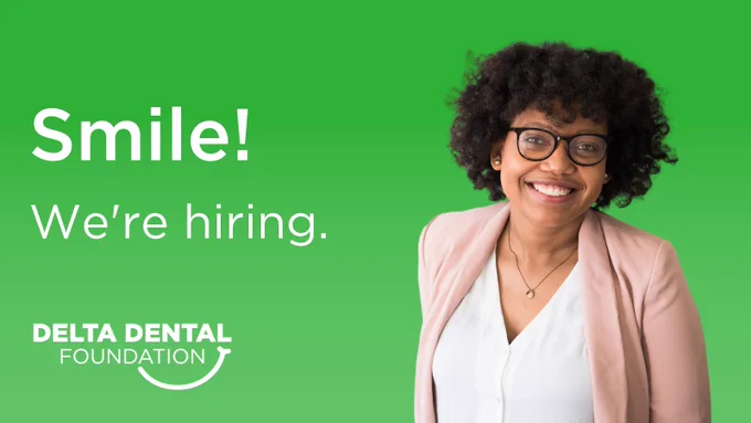  Brown woman in business casual clothing with glasses smiling in front of a green background. Text reads: "Smile! We're hiring." with the Delta Dental Foundation logo