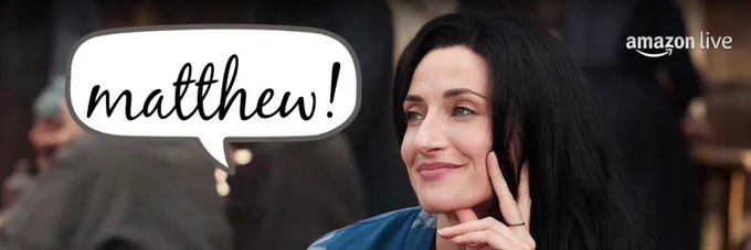 Natasha O’Keeffe as Lanfear in Season 2 of The Wheel of Time sitting with her face in hand smiling with her mouth closed. A white dialogue bubble in front of her that says, Matthew!