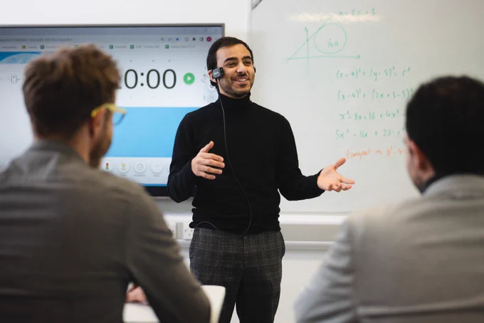 Photo of a man teaching in a classroom wearing the ARxVision headset. 
