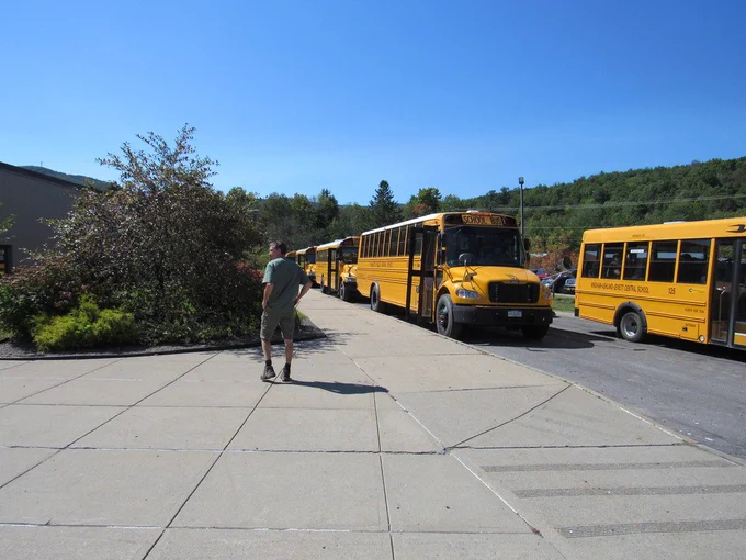 Staff member outside with school buses