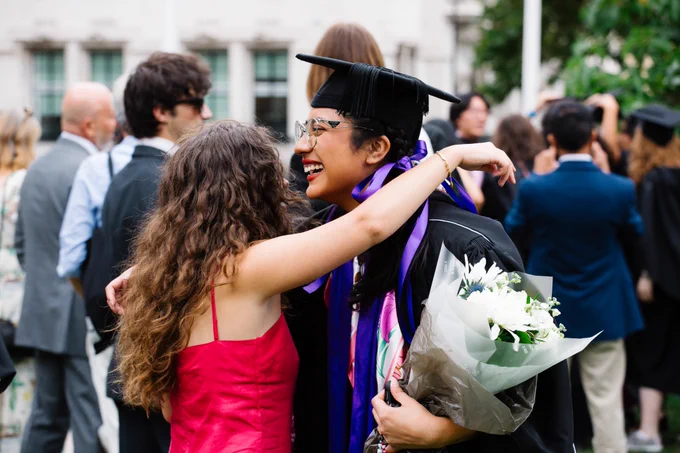 Two students hugging at graduation