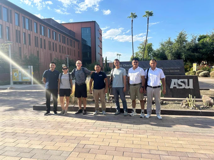 Seven researchers in front of the university entrance