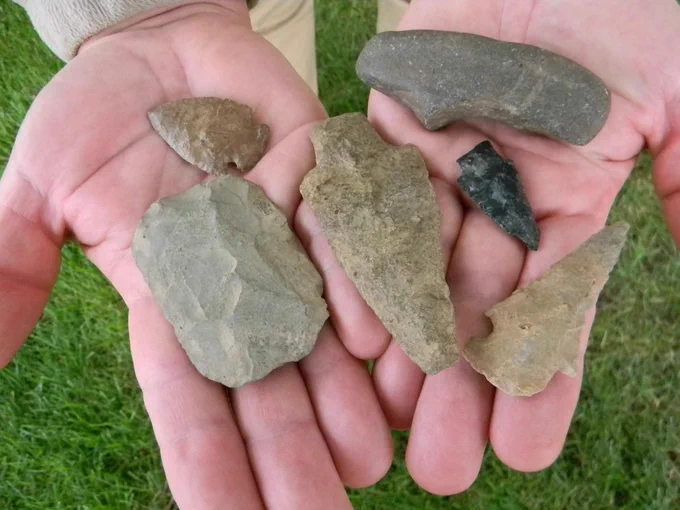 Close up of someone holding a variety of rock-type object in their hands.