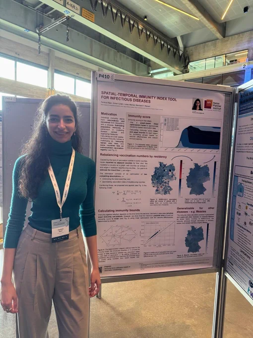 Ferdous Nasri standing happily in front of her poster.