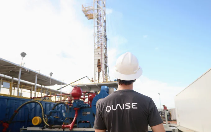 Quaise employee in front of a drilling rig.