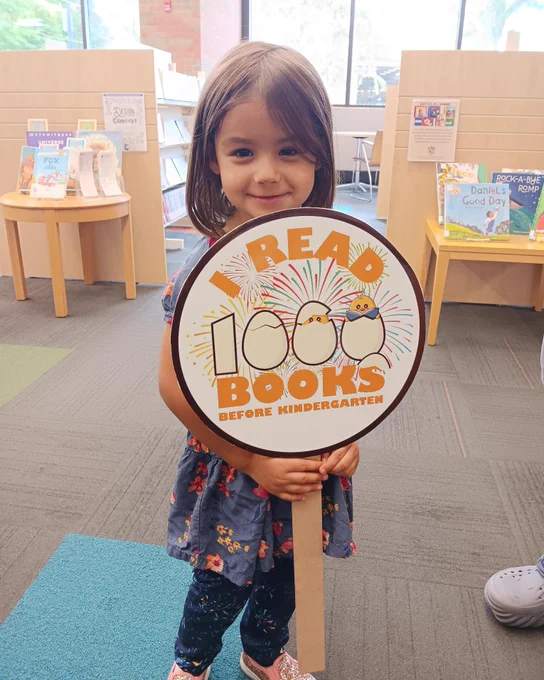 Photo of a young girl who finished the 1000 Books Before Kindergarten reading program.