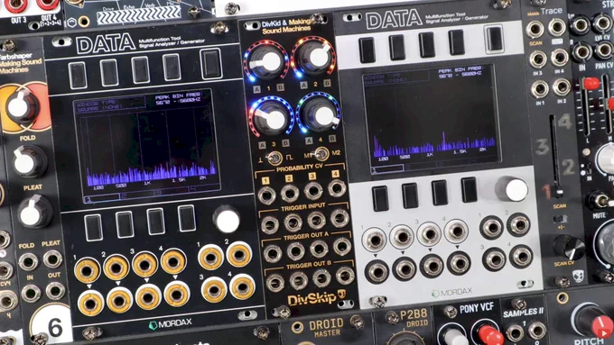 DivKid DivSkip module seen between two oscilloscope visualizers in a Eurorack skiff, showing its four LED-ringed knobs, four channels of trigger inputs, eight trigger outputs, and four probability CV inputs.
