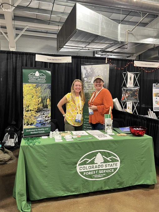 Two employees of Colorado State Forest Service work at conference booth.