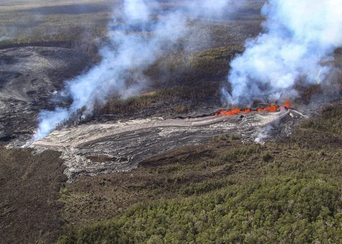 During the USGS Hawaiian Volcano Observatory reconnaissance overflight the morning of September 19, geologists observed the fissure west of Nāpau Crater generating a lava flow that travels northeast before cascading into the crater on the remote middle East Rift Zone of Kīlauea. This aerial view is looking in a south direction, from north of the eruption site. Nāpau Crater is in the left part of the photo. USGS photo by M. Zoeller. 