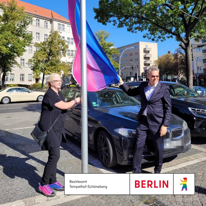Eine Frau und ein Mann hißen eine Flagge