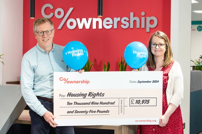 Mark Graham, Co-ownership pictured with Bronagh Flynn, Housing Rights. They are holding a large cheque and Housing Rights balloons.