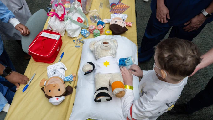 A child playing with a teddy bear.