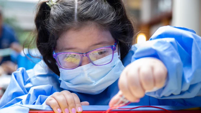 A girl playing Operation.