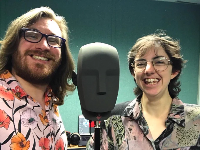 Two people losing with a grey sponge microphone head