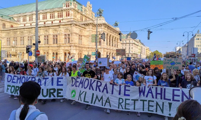 Demonstrationszug vor der Wiener Staatsoper in der Abendsonne und unter wolkenlosem blauen Himmel