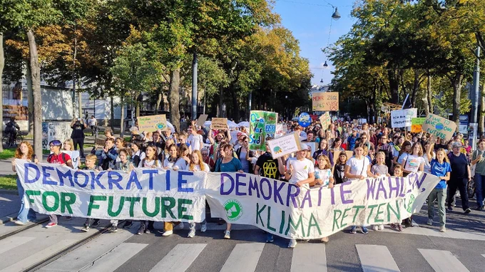 Vor der Spitze des Demonstrationszugs auf der Wiener Ringstraße, auf dem breiten Banner ist zu lesen: "Demokratie for Future, Demokratie wählen - Klima retten"