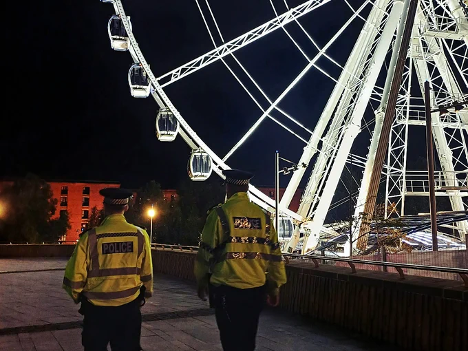 Project Servator officers patrolling in the vicinity of the M&S Bank Arena and The Wheel of Liverpool at night.