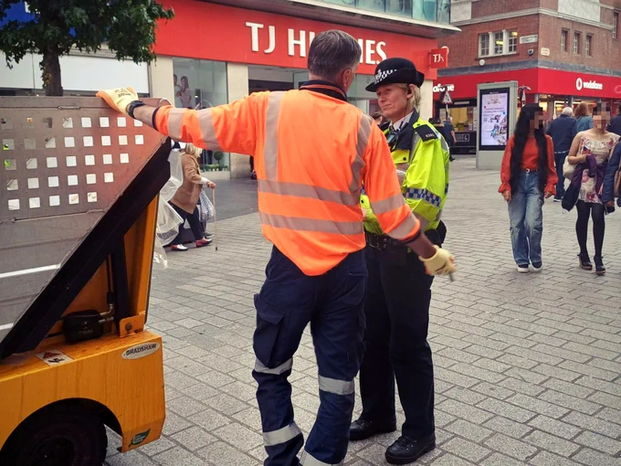 A Project Servator officer speaks with a local authority employee (street cleaning team) in Church Street, Liverpool.
