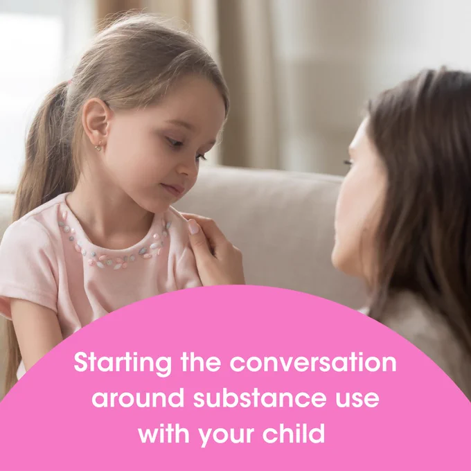 A woman speaking to her child, putting her hand on her shoulder 
