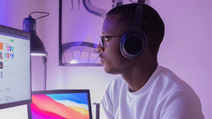 Man in white crew neck shirt wearing black headphones. Photo by Nubelson Fernandes on Unsplash