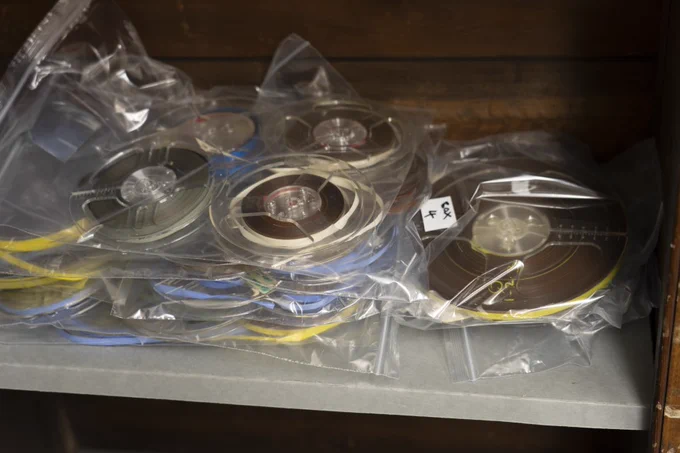 A collection of reel to reel tapes packaged in clear bags, while cleaning and re boxing goes ahead.