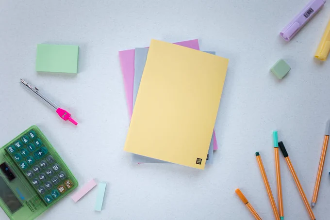 Notebooks, Pens and Calculator Lying on a Desk 