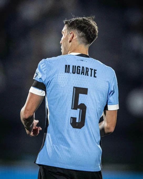 Manuel Ugarte in action for Uruguay, with his back to camera showing his number 5 shirt.