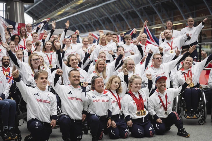 Lots of ParalympicsGB athletes on the platform at London St Pancras station with their medals