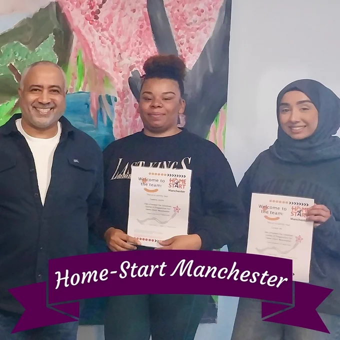 Home-Start volunteers holding certificates and smiling at the camera.