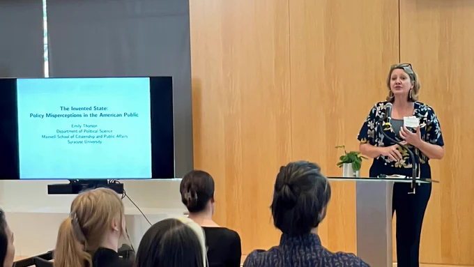 Dr. Danna Young presents at a podium to a captive audience attending the 2024 APSA event in Philadelphia. 