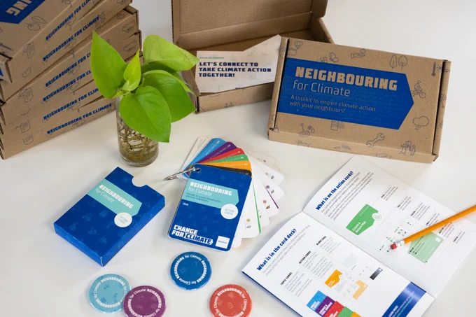 The contents of the Neighbouring for Climate toolkit which includes climate action topic cards, pins and a workbook.