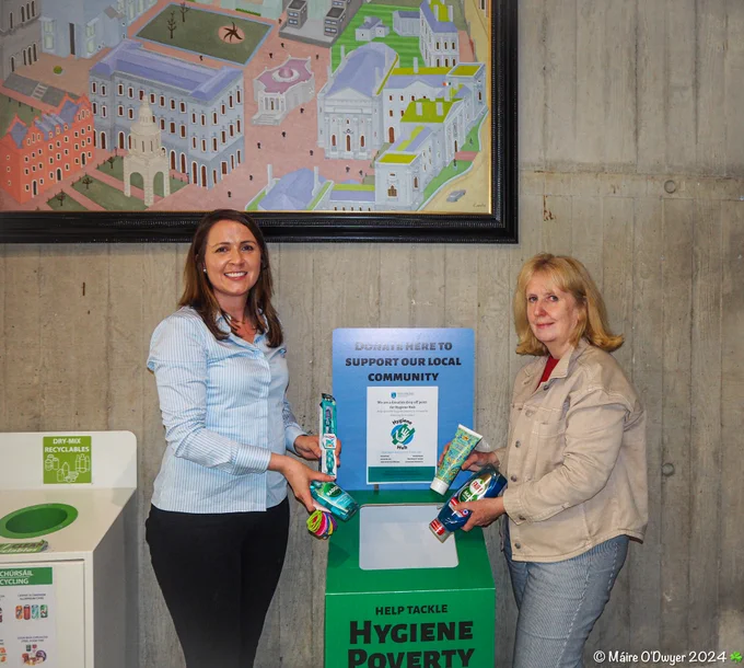 Pictured - Maire O’Dwyer of the School of Pharmacy & Pharmaceutical Science and co-founder of the Hygiene Hub initiative with Iris Bedford, Library colleague holding hygiene products in front of the drop off box in the Library foyer (former Berkeley Library).