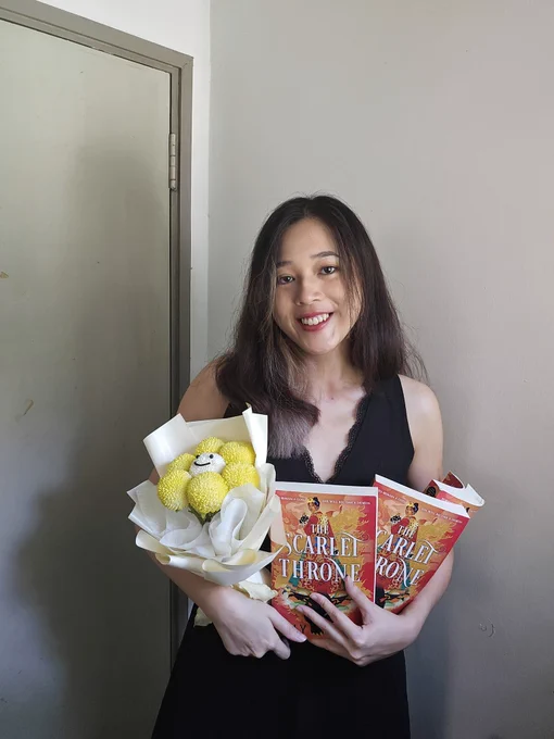 Photo of OP holding 2 copies of The Scarlet Throne and a bouquet of yellow flowers