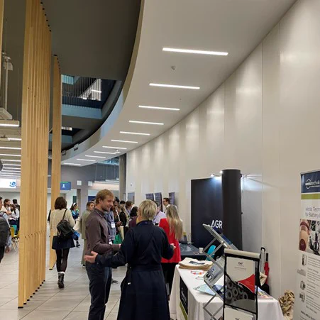 People networking at exhibition stalls.