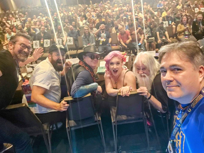 The same 6 people looking the other way with the audience in the background.