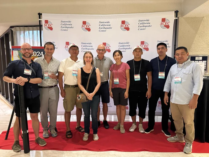 Nine geologists in front of a poster