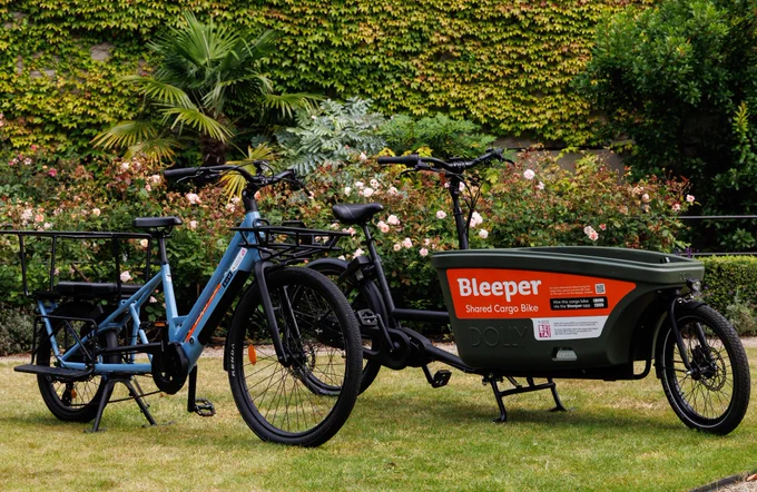 Two cargo bikes - one blue with cargo space at back, one green with large cargo hold at the front.