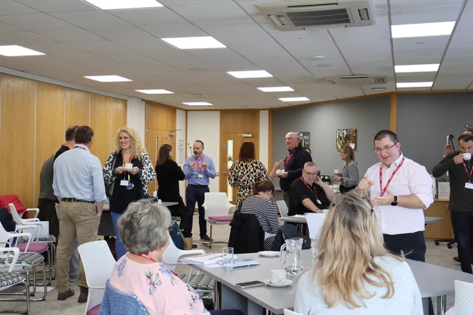 People stood together talking at the Thinking Differently Peer Meeting,