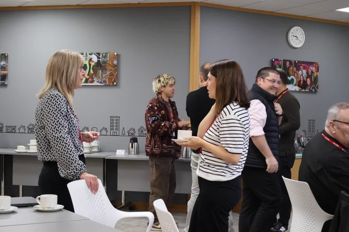 People stood together talking at the Thinking Differently Peer Meeting.